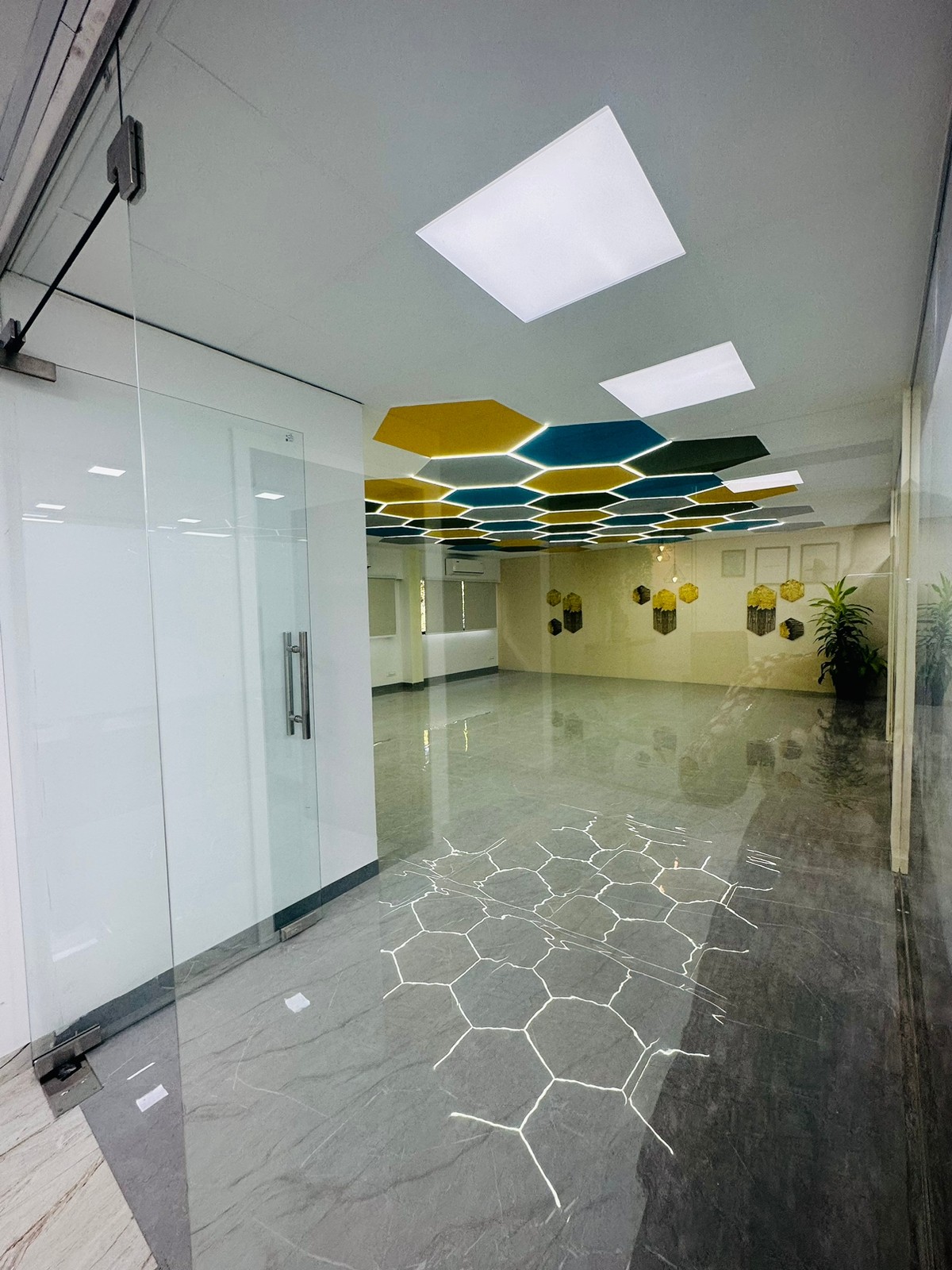 Corridor opening into a room with a teal and yellow hexagon ceiling